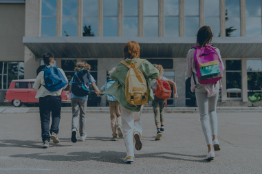 School children with backpacks run into a school